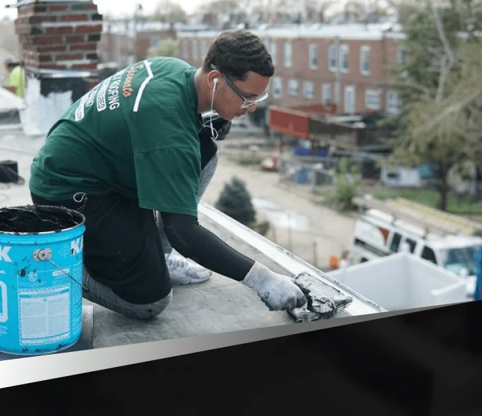Home Spennato Family Roofing Roofing contractor applying flat roof sealant in Northeast Philadelphia